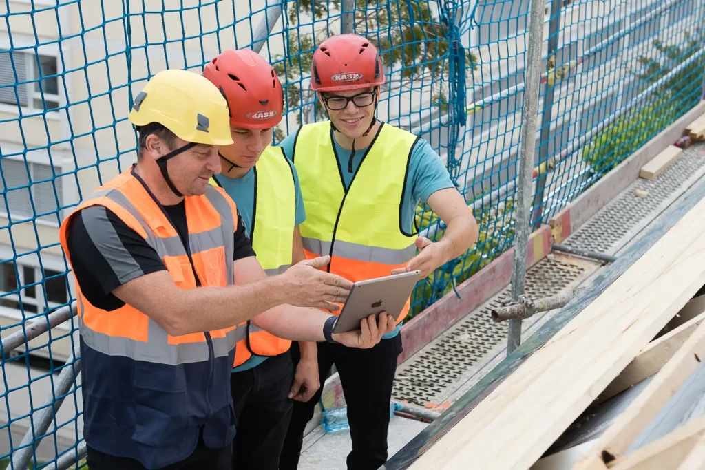 Drei Männer in Warnwesten und Schutzhelmen